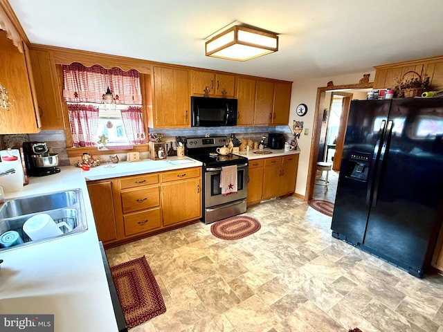 239 S Allison St, Greencastle, PA 17225 - kitchen with black appliances, brown cabinetry, light countertops, and decorative backsplash