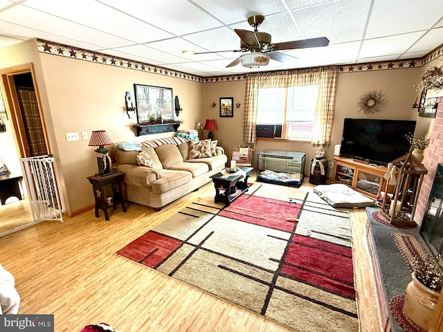 239 S Allison St, Greencastle, PA 17225 - living area with a drop ceiling, ceiling fan, wood finished floors, and a brick fireplace