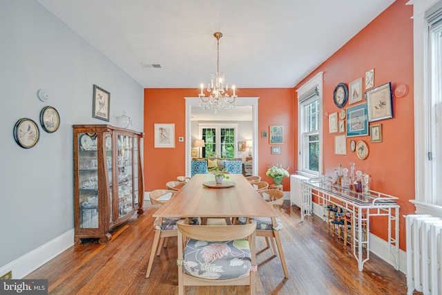 3100 Rodman St NW, Washington, DC 20008 - dining room with radiator heating unit, a chandelier, wood-type flooring, and baseboards