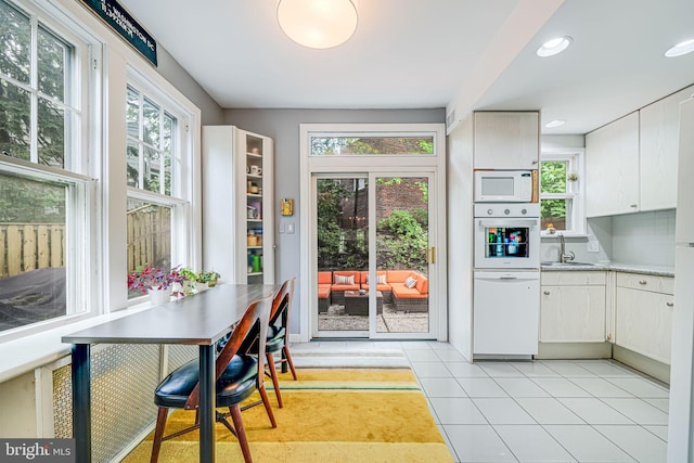 3100 Rodman St NW, Washington, DC 20008 - kitchen featuring white appliances, a sink, light tile patterned flooring, white cabinetry, and recessed lighting