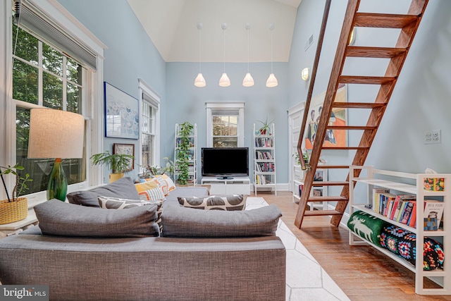 3100 Rodman St NW, Washington, DC 20008 - living room with high vaulted ceiling, stairway, wood finished floors, and healthy amount of natural light