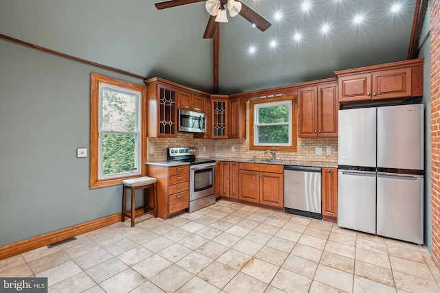 20 N Richardson Ave, Lansdale, PA 19446 - kitchen with appliances with stainless steel finishes, tasteful backsplash, high vaulted ceiling, brown cabinetry, and a ceiling fan