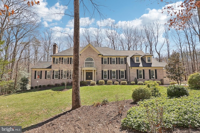 7951 Kelly Ann Ct, Fairfax Station, VA 22039 - colonial-style house with a chimney, a front yard, brick siding, and a shingled roof