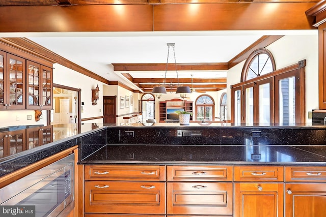 7951 Kelly Ann Ct, Fairfax Station, VA 22039 - kitchen with stainless steel microwave, glass insert cabinets, ornamental molding, open floor plan, and brown cabinetry