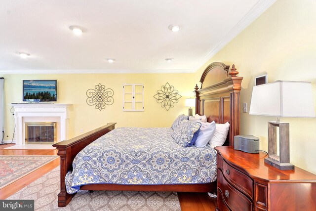 7951 Kelly Ann Ct, Fairfax Station, VA 22039 - bedroom with wood finished floors, a glass covered fireplace, and ornamental molding