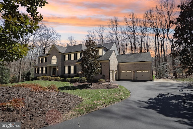 7951 Kelly Ann Ct, Fairfax Station, VA 22039 - view of front of property with driveway, a garage, a yard, stone siding, and a chimney