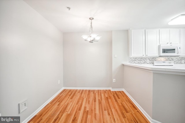 18707 Sparkling Water Dr Unit 3, Germantown, MD 20874 - unfurnished dining area featuring light wood-style flooring, a chandelier, and baseboards