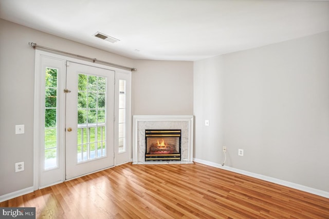 18707 Sparkling Water Dr Unit 3, Germantown, MD 20874 - unfurnished living room featuring healthy amount of natural light, wood finished floors, a premium fireplace, and baseboards