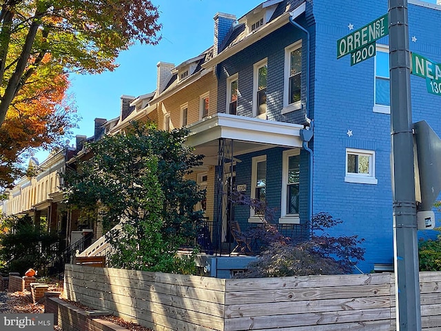1111 Orren St NE Unit 300, Washington, DC 20002 - view of side of home with brick siding, a porch, and a chimney