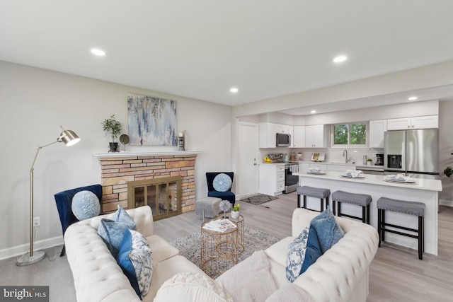 3015 Logan St, District Heights, MD 20747 - living room featuring light wood finished floors, recessed lighting, baseboards, and a stone fireplace
