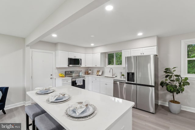 3015 Logan St, District Heights, MD 20747 - kitchen with stainless steel appliances, a sink, tasteful backsplash, light wood-type flooring, and plenty of natural light