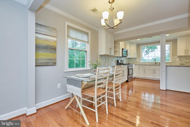6823 Donahue Ct, Falls Church, VA 22042 - dining room featuring a chandelier, ornamental molding, light wood-style floors, and baseboards
