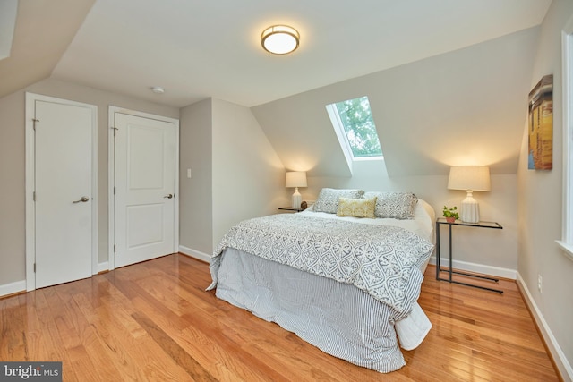 6823 Donahue Ct, Falls Church, VA 22042 - bedroom featuring a skylight, wood finished floors, lofted ceiling, and baseboards