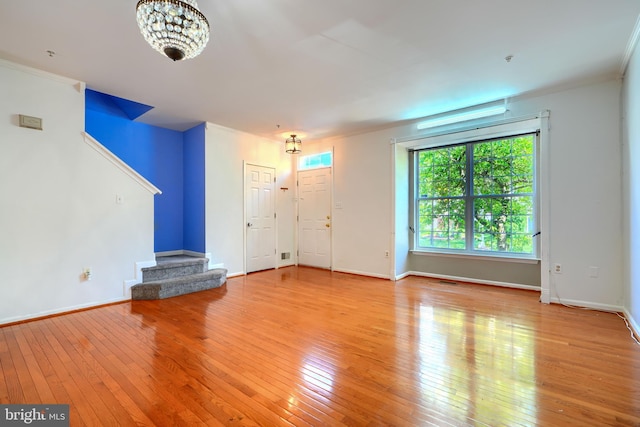 1713 Sea Pine Cir, Severn, MD 21144 - unfurnished living room featuring hardwood / wood-style floors, stairs, baseboards, a chandelier, and crown molding