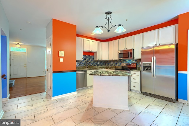 1713 Sea Pine Cir, Severn, MD 21144 - kitchen featuring stainless steel appliances, a center island, backsplash, white cabinets, and hanging light fixtures