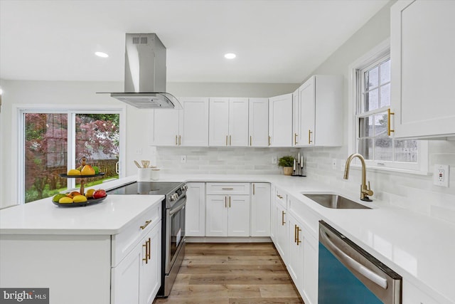 5507 Heatherwood Rd, Baltimore, MD 21227 - kitchen with stainless steel appliances, a sink, island exhaust hood, a peninsula, and light countertops