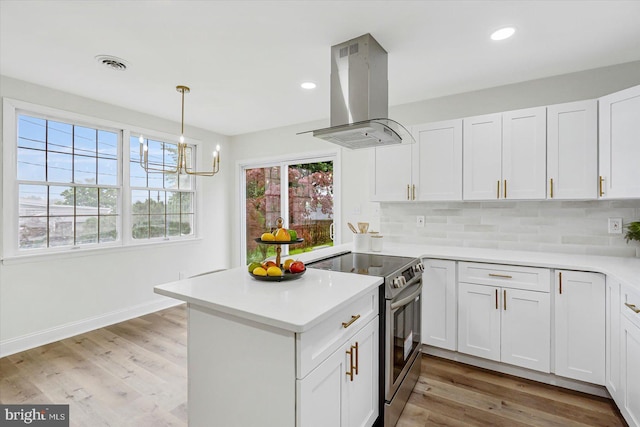 5507 Heatherwood Rd, Baltimore, MD 21227 - kitchen featuring island exhaust hood, stainless steel range with electric cooktop, a peninsula, light countertops, and white cabinets