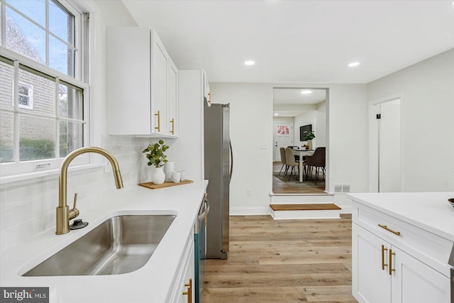 5507 Heatherwood Rd, Baltimore, MD 21227 - kitchen featuring a sink, freestanding refrigerator, light wood-type flooring, white cabinetry, and recessed lighting