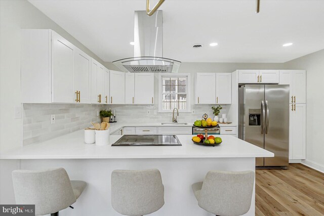 5507 Heatherwood Rd, Baltimore, MD 21227 - kitchen featuring stainless steel fridge, island exhaust hood, a sink, cooktop, and a peninsula