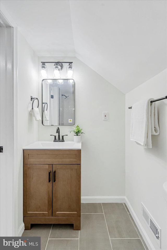 5507 Heatherwood Rd, Baltimore, MD 21227 - full bath featuring vanity, vaulted ceiling, tile patterned floors, baseboards, and a shower
