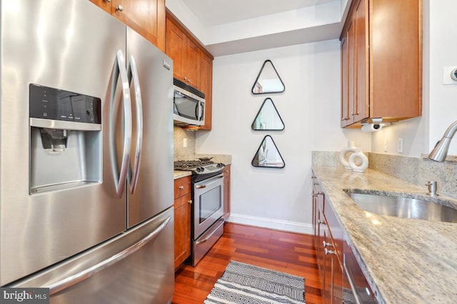 531 T St NW Unit 101, Washington, DC 20001 - kitchen featuring appliances with stainless steel finishes, a sink, brown cabinetry, dark wood finished floors, and baseboards