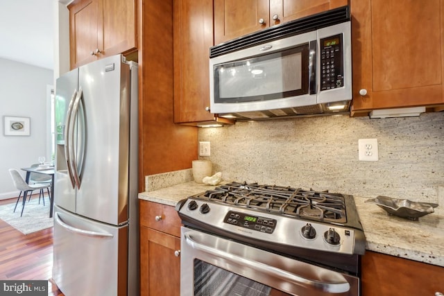 531 T St NW Unit 101, Washington, DC 20001 - kitchen featuring appliances with stainless steel finishes, tasteful backsplash, and brown cabinets