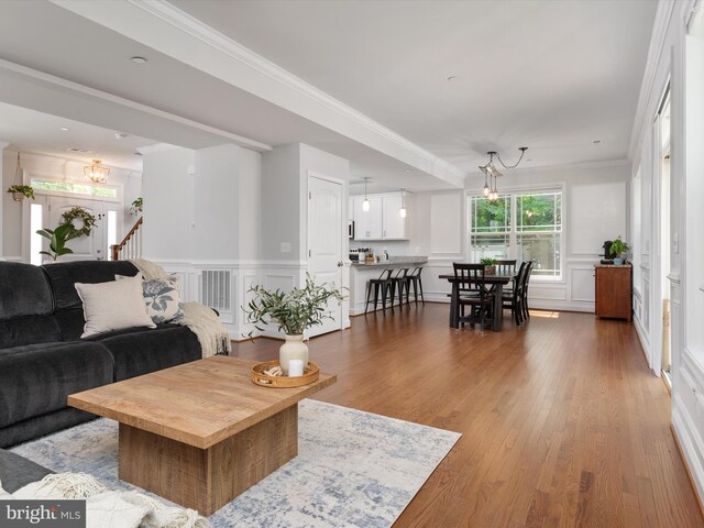 933 Winding Rd, Edgewater, MD 21037 - living area with a chandelier, a decorative wall, ornamental molding, wainscoting, and wood finished floors