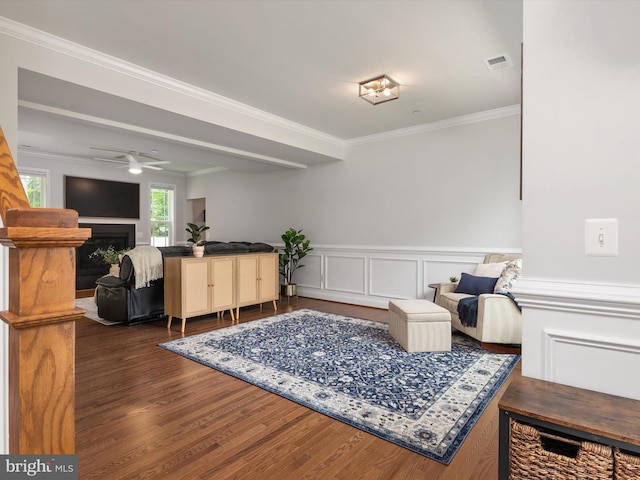 933 Winding Rd, Edgewater, MD 21037 - sitting room featuring wood finished floors, crown molding, a ceiling fan, a fireplace, and a wainscoted wall