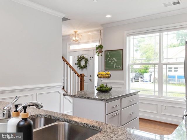 933 Winding Rd, Edgewater, MD 21037 - kitchen with a sink, a decorative wall, ornamental molding, a chandelier, and stone countertops