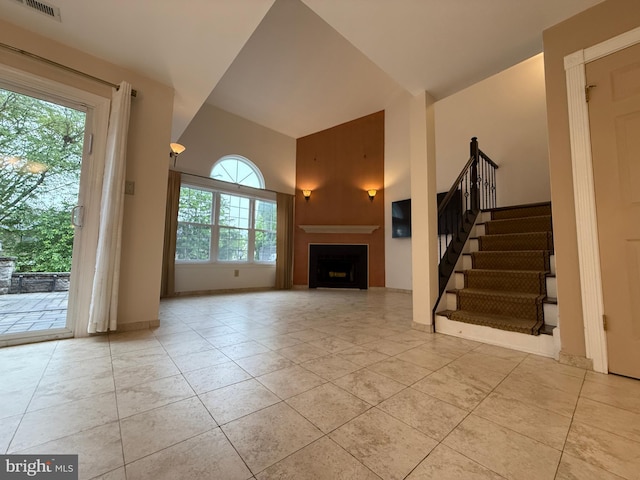15 E Park Rd, Newtown, PA 18940 - unfurnished living room with a towering ceiling, a fireplace, stairs, and light tile patterned floors