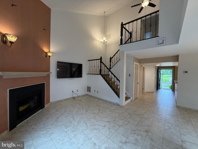 15 E Park Rd, Newtown, PA 18940 - unfurnished living room featuring a ceiling fan, stairway, a towering ceiling, a fireplace, and baseboards