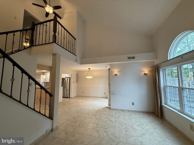 15 E Park Rd, Newtown, PA 18940 - unfurnished living room featuring high vaulted ceiling, plenty of natural light, stairs, ceiling fan, and baseboards