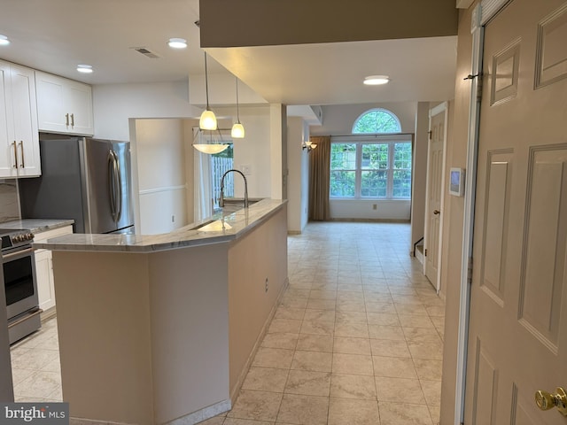 15 E Park Rd, Newtown, PA 18940 - kitchen with stainless steel appliances, white cabinets, light stone counters, decorative light fixtures, and recessed lighting