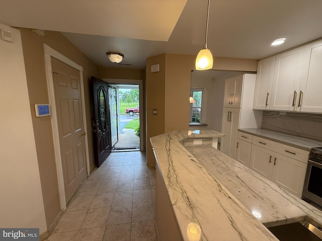 15 E Park Rd, Newtown, PA 18940 - kitchen featuring white cabinetry, light stone countertops, light tile patterned floors, and baseboards