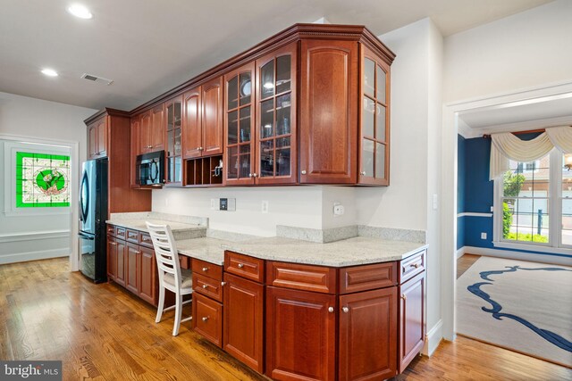 4729 Grand Masters Way, Woodbridge, VA 22192 - kitchen with black microwave, freestanding refrigerator, light wood-style floors, built in study area, and light stone countertops