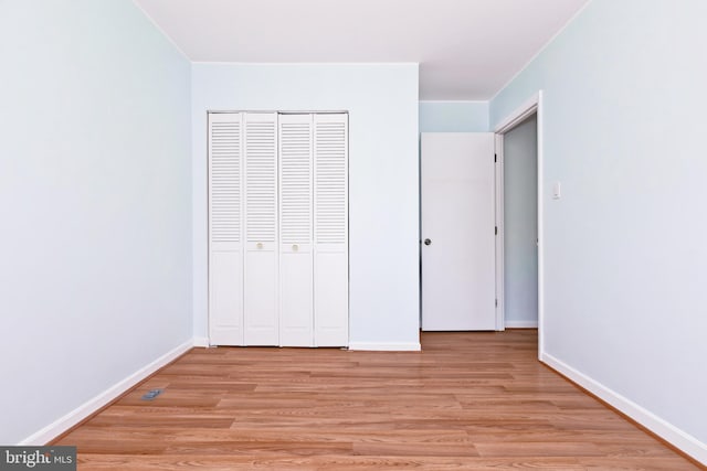 14520 Sorrento Ct, Burtonsville, MD 20866 - unfurnished bedroom with light wood-style floors, a closet, and baseboards