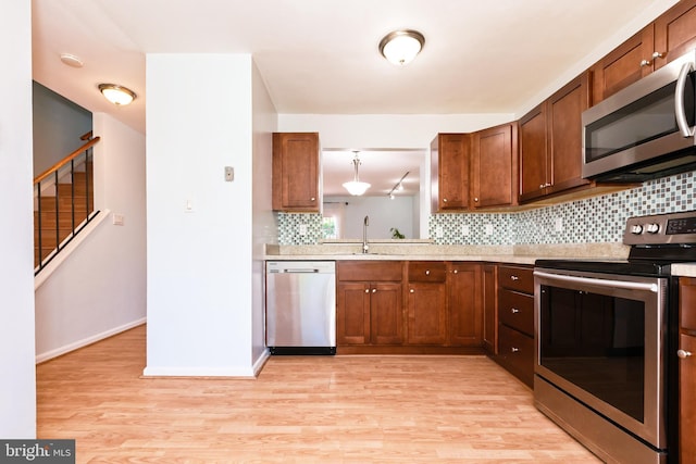14520 Sorrento Ct, Burtonsville, MD 20866 - kitchen featuring stainless steel appliances, light wood finished floors, backsplash, light countertops, and baseboards