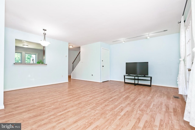 14520 Sorrento Ct, Burtonsville, MD 20866 - unfurnished living room with wood finished floors, stairway, track lighting, and baseboards