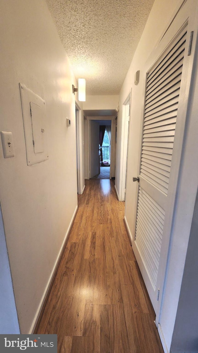 2921 N Leisure World Blvd Unit 418, Silver Spring, MD 20906 - hall with electric panel, wood finished floors, a textured ceiling, and baseboards