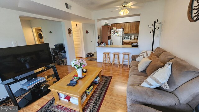 2921 N Leisure World Blvd Unit 418, Silver Spring, MD 20906 - living area with washer / dryer, ceiling fan, and light wood-style flooring