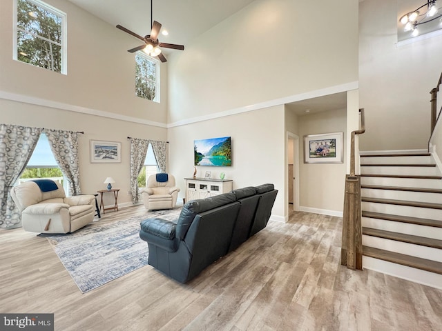 22543 Bradbury Way, Georgetown, DE 19947 - living room featuring a towering ceiling, ceiling fan, wood finished floors, baseboards, and stairway