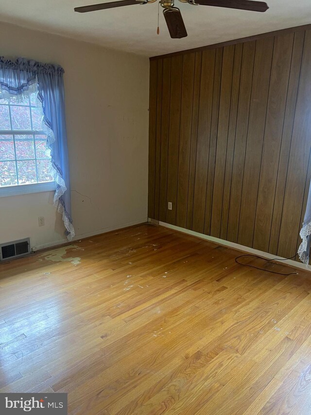 5933 Rawley Pike, Rockingham, VA 22801 - spare room with a ceiling fan, light wood-type flooring, and wood walls