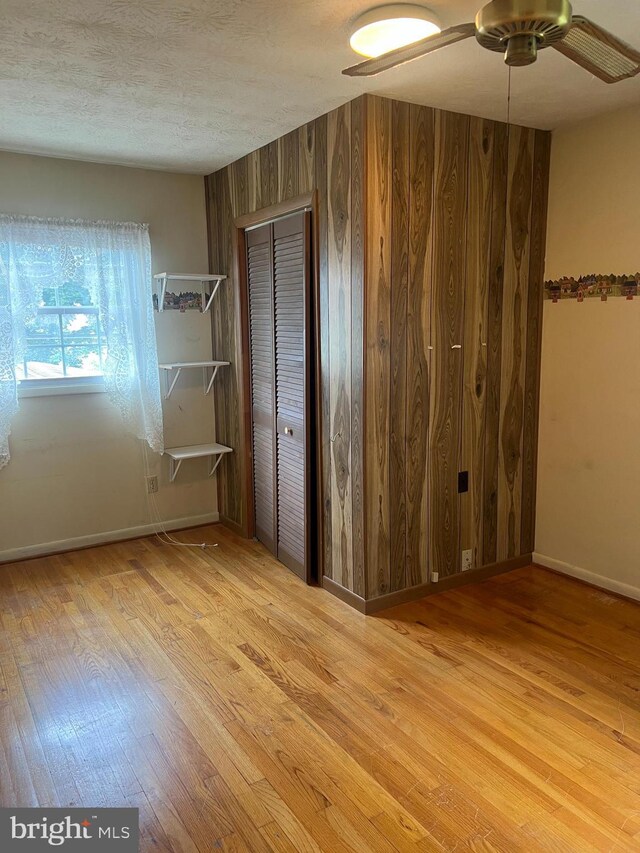 5933 Rawley Pike, Rockingham, VA 22801 - unfurnished bedroom with wood finished floors, baseboards, wooden walls, and a closet