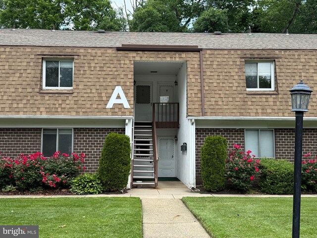 411 N Stiles Ave Unit A5, Maple Shade, NJ 08052 - view of front facade featuring a shingled roof, brick siding, mansard roof, and a front yard