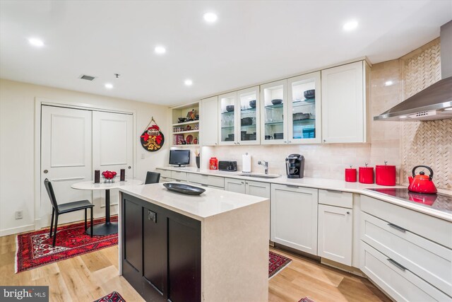 5610 Wisconsin Ave Unit 406, Chevy Chase, MD 20815 - kitchen with wall chimney exhaust hood, electric stovetop, open shelves, white cabinetry, and light countertops
