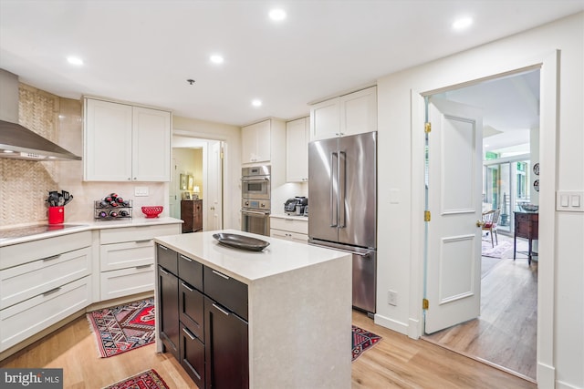 5610 Wisconsin Ave Unit 406, Chevy Chase, MD 20815 - kitchen with appliances with stainless steel finishes, light countertops, light wood-style floors, backsplash, and recessed lighting