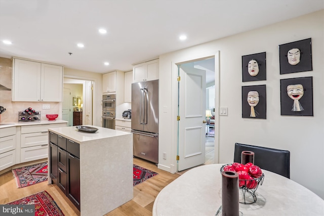5610 Wisconsin Ave Unit 406, Chevy Chase, MD 20815 - kitchen featuring appliances with stainless steel finishes, light countertops, recessed lighting, light wood-style flooring, and white cabinetry