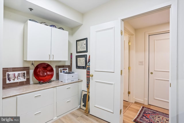 5610 Wisconsin Ave Unit 406, Chevy Chase, MD 20815 - kitchen featuring light wood-style floors, white cabinetry, and light countertops