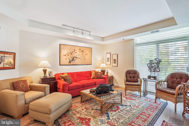 5610 Wisconsin Ave Unit 406, Chevy Chase, MD 20815 - living room featuring rail lighting, wood finished floors, and a raised ceiling