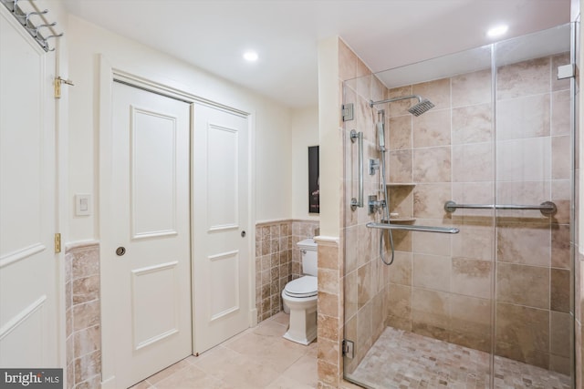 5610 Wisconsin Ave Unit 406, Chevy Chase, MD 20815 - bathroom featuring tile walls, a stall shower, wainscoting, tile patterned flooring, and recessed lighting